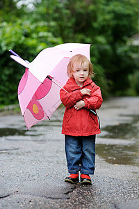 秋天下雨时的可爱小孩女孩童年孩子外套天气乐趣人行道微笑农村红色季节图片