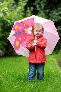 秋天下雨时的可爱小孩女孩靴子红色人行道童年雨衣雨滴农村乐趣季节天气图片