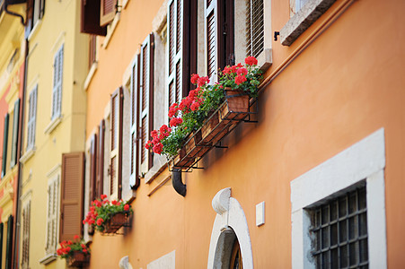 意大利一个色彩多彩的阳台财产花朵快门建筑学衣服躺椅房子窗户橙子椅子图片