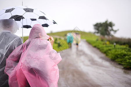 一对穿雨衣的情侣 在雨伞下图片