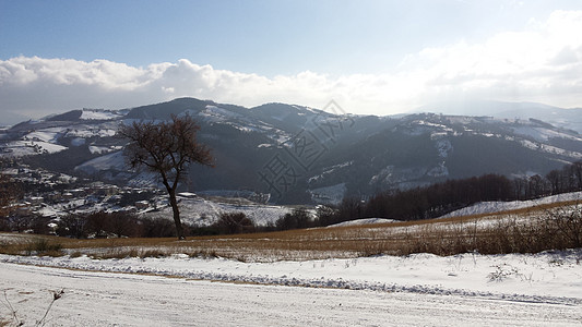 Umbria农村地区靠近Gubbio 冬季下雪下的Gubbio阳光明媚的一天有雪覆盖的美丽风景山脉日落高原观光旅游村庄旅行蓝色农图片