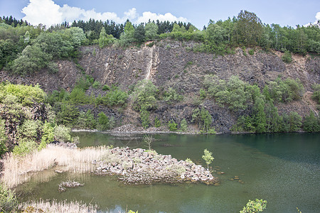 山坡由湖边的拜萨尔特岩石制成火山岩表面喷发自然公园树木天空矿物质棕色树叶蓝色图片