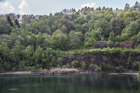 山坡由湖边的拜萨尔特岩石制成绿色蓝色自然公园表面火山岩矿物质喷发植物树叶棕色图片
