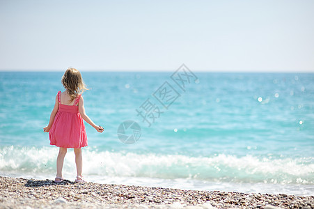 小女孩在一个小石头沙滩上图片