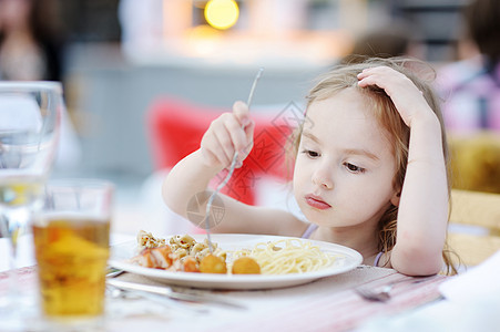 可爱的小女孩吃意大利面女性面条女孩营养好奇心童年食物孩子头发饥饿图片