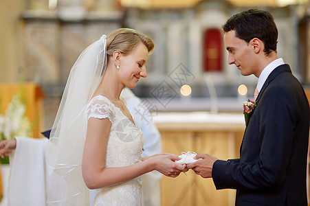 持有结婚戒指的新娘和新郎头发仪式传统手指蕾丝男性婚礼金子教会婚姻图片