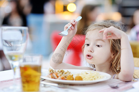 可爱的小女孩吃意大利面童年桌子食欲女性食物孩子好奇心头发眼睛饥饿图片