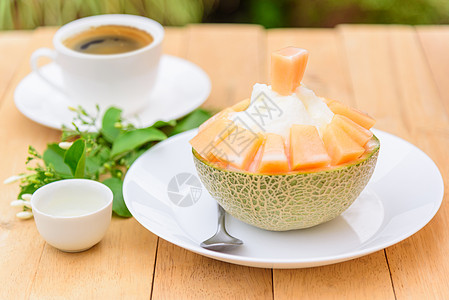 木桌上有甜甜冷凝固牛奶的环冰甜瓜杏仁食物奶油香草料理果味桌子浇头美食图片