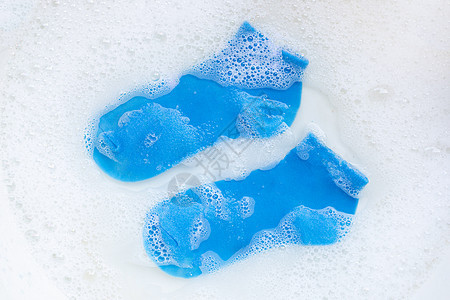 蓝色袜子浸泡在粉末洗涤水溶解中图片
