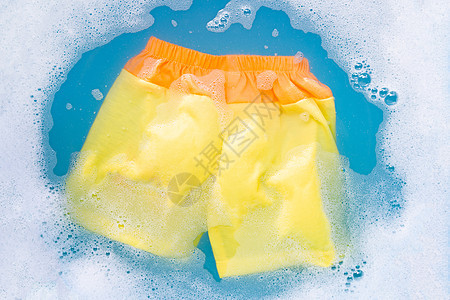 黄色和橙色婴儿短裤浸泡在婴儿洗衣洗涤剂瓦特中玩具乐趣男生纺织品家庭新生衣服卫生家务绳索图片
