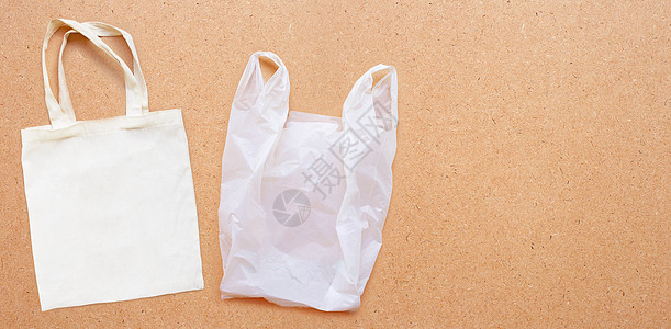 胶合板背景上带白色塑料袋的白色织物袋环境展示店铺运动背包织物细绳购物市场棉布图片