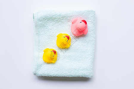 白底软绿毛巾上的粉和黄鸭玩具图片