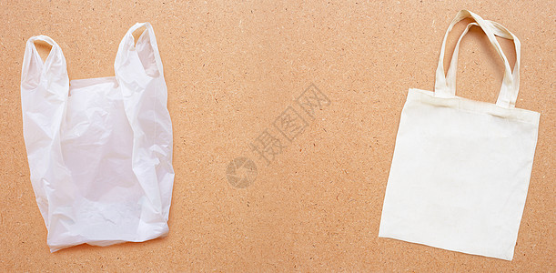 胶合板背景上带白色塑料袋的白色织物袋帆布环境衣服材料生态棉布回收购物背包绳索图片