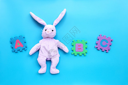 蓝背景上用英文字母拼图的兔子玩具收藏幼儿园乐趣蓝色教育孩子们孩子婴儿盒子学习图片