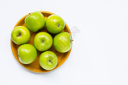 黄色盘子上的新鲜绿苹果 白色背景图片