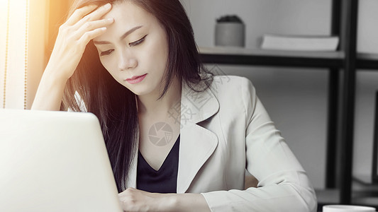 年轻的亚洲压力女性在工作 抑郁的女性在办公室 美丽的年轻亚洲女性的画像感到恶心 头痛 办公室综合症 工作中的医疗保健概念图片