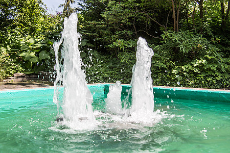 绿池喷泉树木水柱盆地植物蓝色明镜树叶绿色花园反思图片