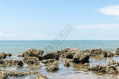 海滩和海与蓝天和礁岩海滩石头阳光蓝色波浪珊瑚牡蛎地平线架子旅行石灰石图片