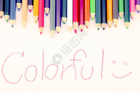 从彩色铅笔的背景用手在白纸上写五颜六色 教育框架概念彩虹木头粉色绿色白色绘画黄色红色蓝色蜡笔图片