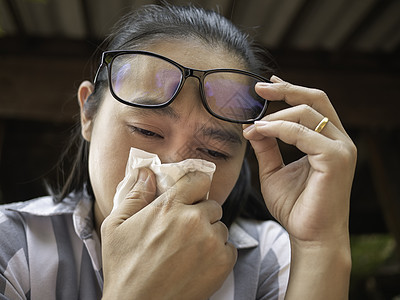 亚裔年轻女子用握住的组织和吹鼻孔打眼镜 流鼻涕 流感季节 健康和医疗概念女孩鼻子过敏咳嗽症状发烧感染眼镜疾病喷嚏图片