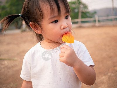 快乐的亚洲小女孩 吃冰淇淋如此美味 在公园孩子衬衫甜点奶油女孩幸福食物天气童年乐趣图片