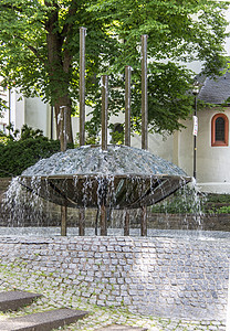 教堂前的彩色喷泉市场树木树叶飞碟石膏石头绿色路面雕塑金属背景图片