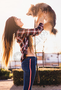 带着可爱的狗和文本复制空间的快乐女人女士公园头发朋友们青年女孩犬类乐趣动物宠物图片