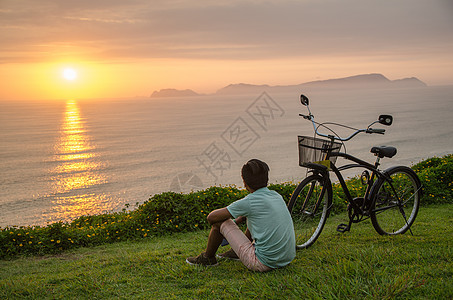 骑自行车的男孩男生海岸孩子运动海滩太阳娱乐日落假期场地图片