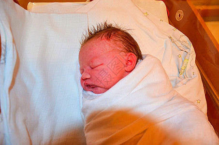新出生的婴儿医院里的女孩 刚出生的女婴  3 5 小时大  穿着保暖的衣服引擎盖侧位房间新生皮肤婴儿期小时帽子母性童年图片