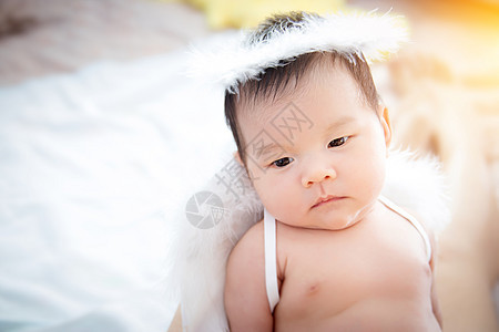 特写美丽的新生女婴 一个戴着天使翅膀和天使戒指的美丽新生女婴的画像图片
