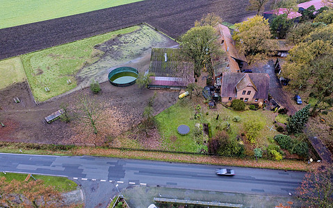 德国一个农场的空中景象 前方有一条路草地小屋农业场地农家绿色植物沥青住房住宅地标图片