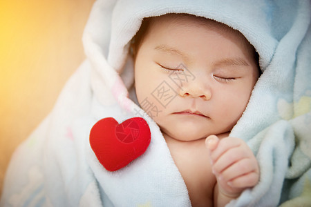 家庭爱情关系概念 红色心形睡可爱的亚洲婴儿 可爱的新生儿亚洲女婴在她的第一年图片