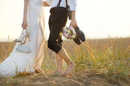 日落时在海滩的新娘和新郎图片