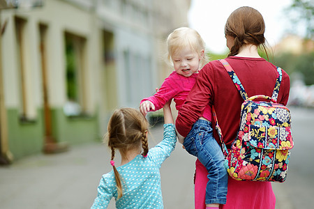 年轻母亲和两个可爱的女儿在户外女孩孩子夹克婴儿姐姐公园兄弟母性微笑父母图片