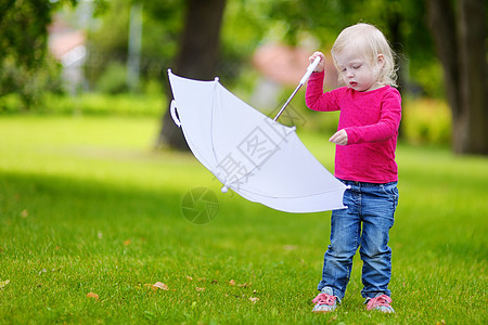 可爱的小女孩在户外玩得开心孩子沉淀享受幸福青年阳伞女孩快乐姿势草地图片