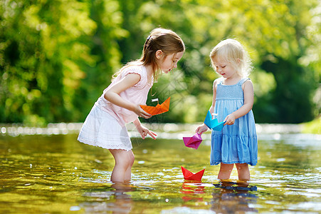 两个小妹妹玩纸船的两姐妹女孩公园姐姐季节家庭兄弟池塘朋友们童年幸福图片