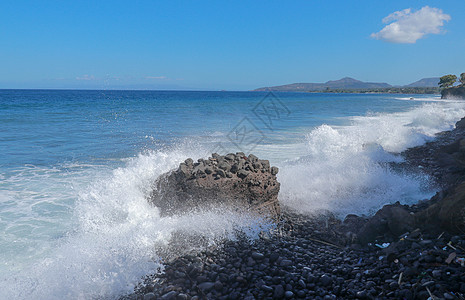 海浪拍打在石滩上 形成一个大浪花 在热带风暴期间 巨浪撞击岩石 强大的海浪冲击着印度尼西亚巴厘岛的黑色岩石力量支撑飞溅碰撞旅行天图片