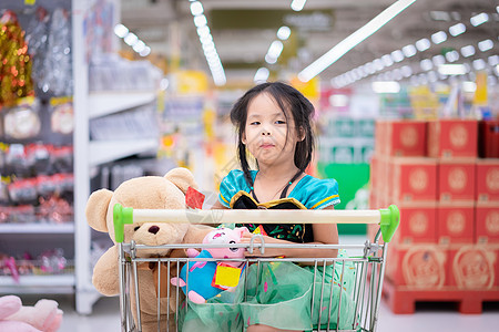 穿着公主服装的亚洲小女孩 坐着洋娃娃坐在那里杂货店扮演女儿销售购物者玩具食物微笑大车家庭图片