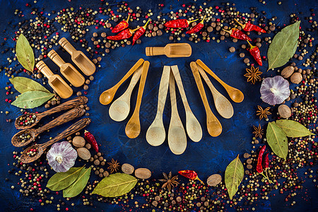 深蓝色背景上的各种调味料和木勺子食物食谱胡椒厨房美食乡村菜单香气藏红花香料图片