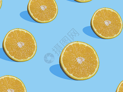 蓝色背景上的新鲜橙色切片与阴影顶部向上模式 夏季和健康的柑橘类水果概念图片