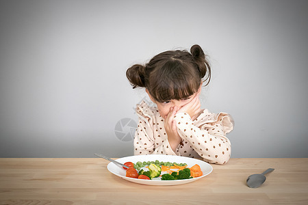 儿童概念的营养和健康饮食习惯 孩子不喜欢吃蔬菜 可爱的小混血女孩拒绝吃健康的蔬菜绿色食客孩子们早餐童年午餐食物勺子盘子婴儿图片