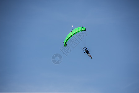Skydiver在飞行中的滑翔伞上伞兵降落伞绳索蓝色天空字符串航空气球丝绿色黄色图片