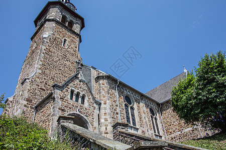 的古老基督教教堂天空石工灌木丛绿色钟楼寺庙棕色灌木蓝色历史图片