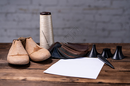 皮鞋和木制鞋的样本 最后放在黑木制桌子上笔记鞋类工具模具制作者生产手工业工艺担架手工图片