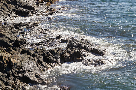 泡沫头水中的岩石天空天气旅行海滩海岸海浪蓝色海景石头海洋图片