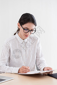 一名身戴眼镜的女商务人士 带着微笑和哈平Happpine一起工作桌子电脑快乐享受商业女孩技术职场女士笔记本图片