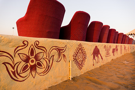 近距离拍摄红色泥土甘蔗椅子沙发和小黄砖墙 让参观者在表演时坐席 背景是沙漠沙子蓝天乐趣娱乐座位帐篷营地旅游公路旅行壁画图片