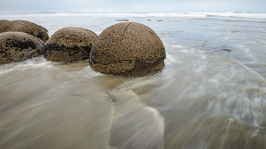 太平洋模糊波浪中的莫拉基巨石图片