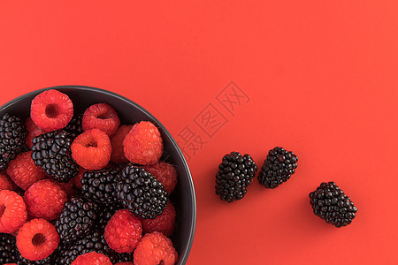 清爽风景黑莓和草莓在黑碗里 红色背景 顶层风景甜点收成营养味道排毒水果季节荒野饮食浆果背景