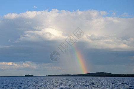 彩虹在湖面的单一云下岛屿岩石光谱下雨森林阳光晴天地平线天气反射图片